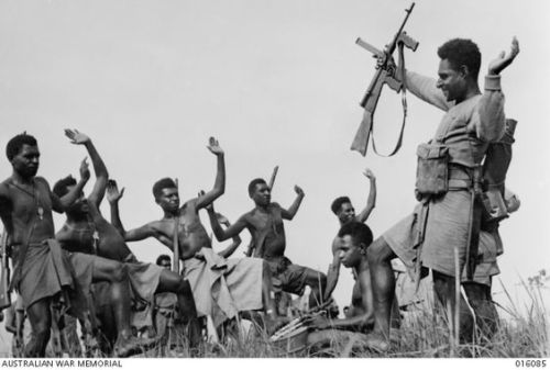 Members of a Papuan Infantry Battalion unit celebrate a successful engagement with the Japanese with