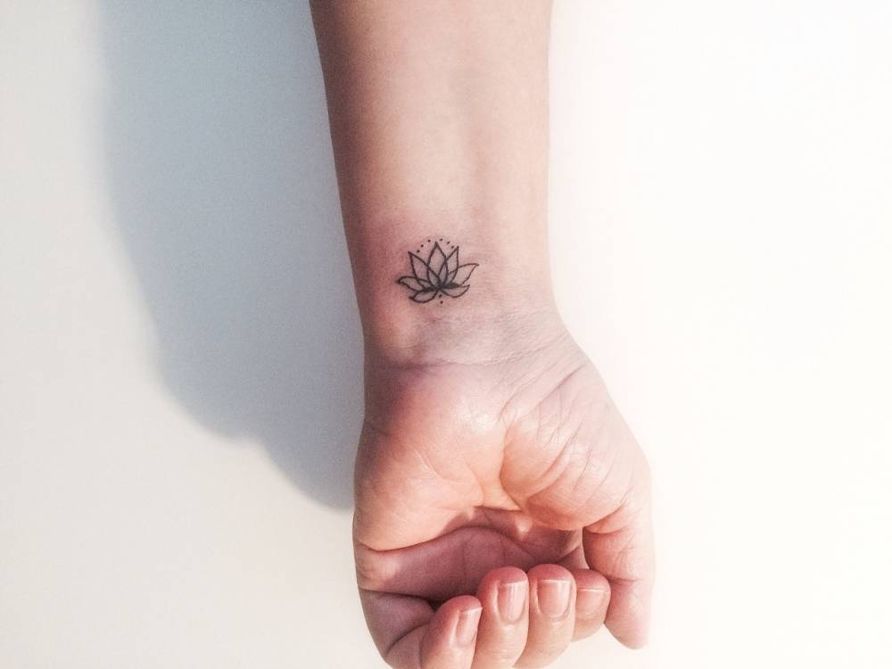 Tatuajes Pequeños — Tatuaje de una flor de loto minimalista en el...