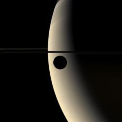 just&ndash;space:  Saturn and its moon Rhea, photographed in color a few years ago by the CassiniHuygens probe. At right, the shadows cast by Saturns rings are clearly visible.  photo credit: Cassini Imaging Team, NASA