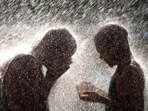 Kids playing or &ldquo;praying&rdquo; under the water towers in the Millennium Park in Chica