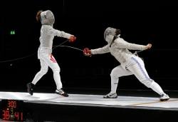 modernfencing:  [ID: two sabre fencers in a bout. The fencer on the left is parrying a low attack.] Ann Huimin Lee (left) against Alice Watson! 