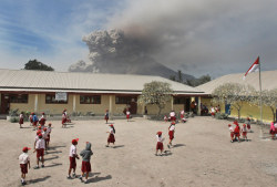 aseahag:  Students play on their school yard as Mount Sinabung erupts in Sukandebi, North Sumatra, Indonesia.