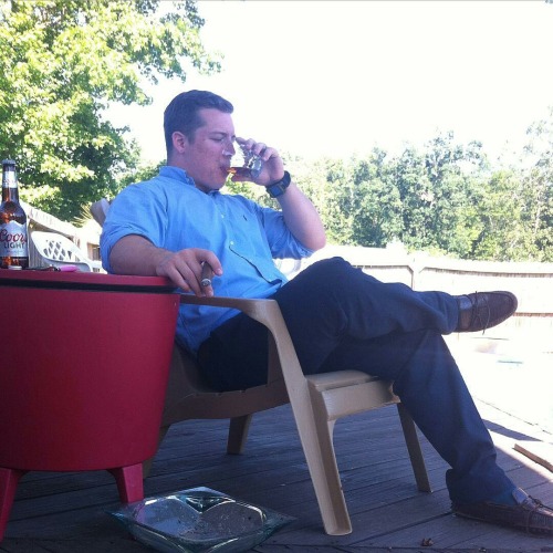 Nice drink, good cigar, and fine weather. All he need is his guy and his weekend will be off to a gr