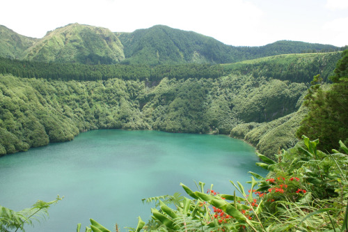 Lagoa de Santiago, a small crater lake in the westernmost part of São Miguel island, hidden between wooded slopes of an ancient volcano.