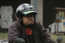 The face the man makes while riding his motorcycle.