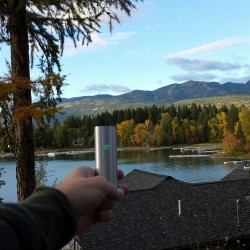 Holding a pax vaporizer looking at the mountains