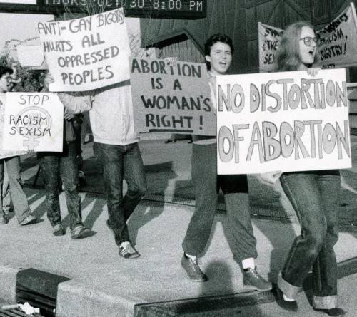 “STOP RACISM & SEXISM” – “ANTI-GAY BIGOTRY HURTS ALL OPPRESSED PEOPLES&r