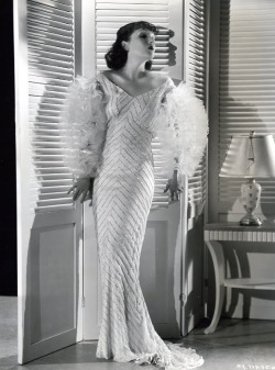 costumefilms:  Strictly Dynamite (1934) - Lupe Velez as Vera wearing an off-shoulder dress with beaded herringbone motif and tulle ruffled sleeves. The costumes were designed by Walter Plunkett. 