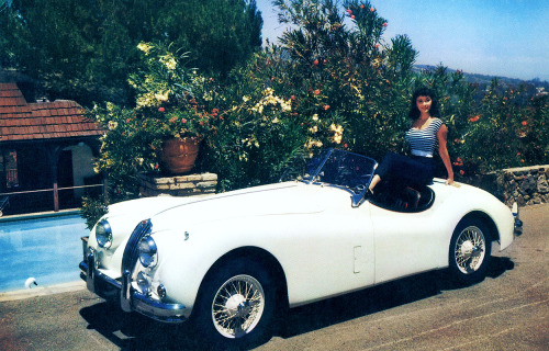 Marla English / posing with a 1956 Jaguar XK 140 Roadster in a publicity still for Gilbert Kay&rsquo