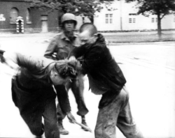 historicaltimes:  An American soldier of the 45th Infantry Division of the U.S. Army National Guard does not interfere as a liberated prisoner at Dachau concentration camp assaults a camp guard in retaliation. April 29th, 1945. via reddit