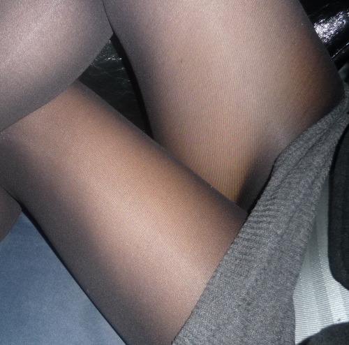 in-pantyhose: Close up of legs in black pantyhose under knitted dress. Woman in pantyhose