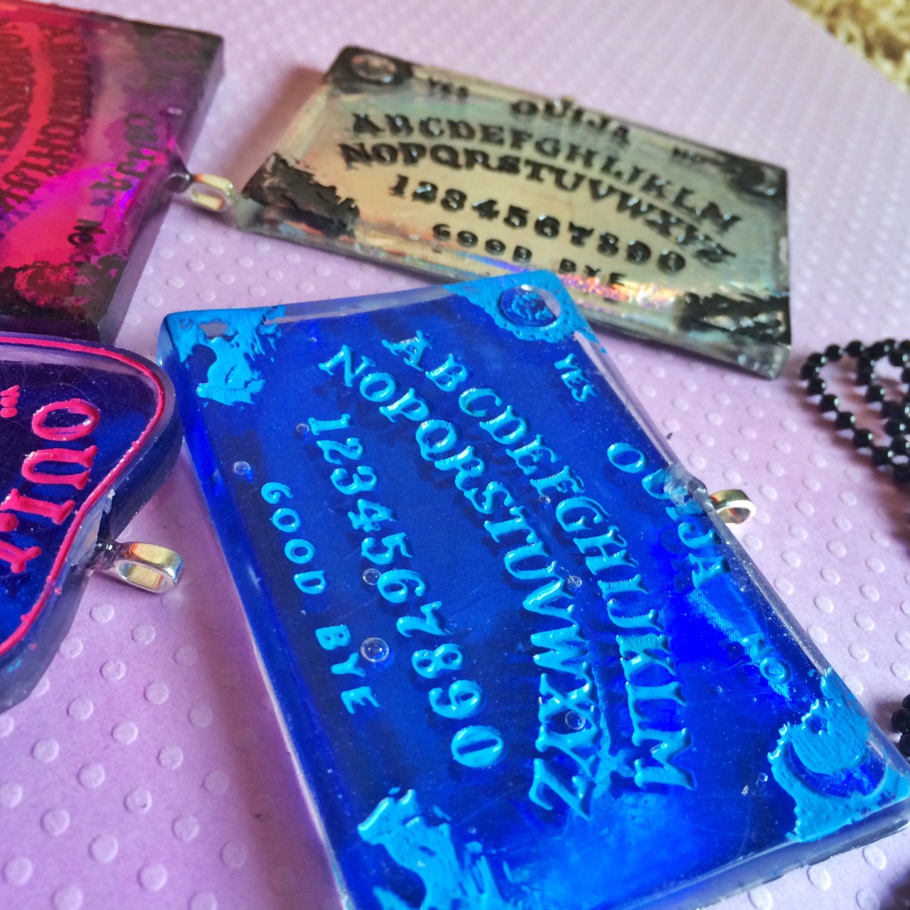jinxandcurses:  NEW! Holographic ouija boards in planchettes in pink, purple, blue,