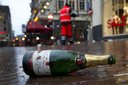 cameralens:  Evert Elzinga/EPA An empty bottle on New Year’s Day is left on New Year’s Day in Leidseplein, Amsterdam. Cleaners were up early to clean up the remaining debris after the celebrations.