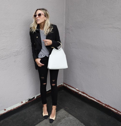 Jacey Duprie has paired black jeans with a horizontally striped tee, a striking white handbag, 