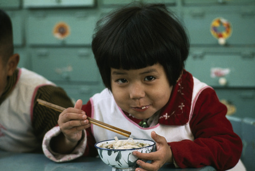 unrar:    A child smiles in between bites of hot noodles, Taiwan, Frank and Helen