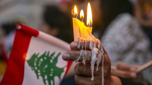 Tunisians light candles during a demonstration in support of Lebanese people following the powerful 