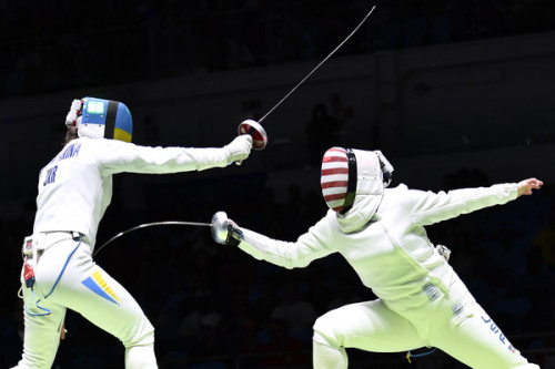 modernfencing:[ID: an epee fencer lunging and hitting her opponent.]Yana Shemyakina (left) against C