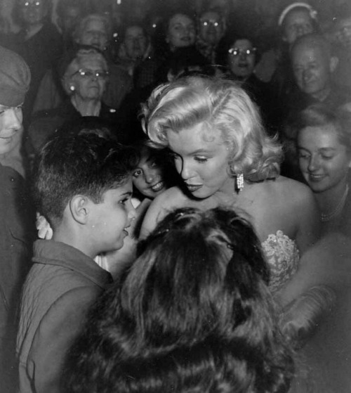 Marilyn Monroe takes a moment to talk to a young fan during the premiere of How to Marry a Millionai