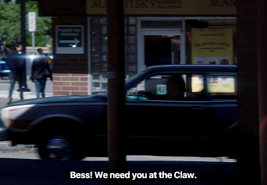 GIF FROM EPISODE 3X01 OF NANCY DREW. ACE PULLS HIS CAR UP TO AN ABRUPT STOP AND LEANS AN ARM OUT OF THE WINDOW. HE SAYS "BESS! WE NEED YOU AT THE CLAW." THE SHOT CUTS TO BESS SITTING AT A TABLE OUTSIDE OF A CAFE. SHE SITS UP STRAIGHTER AND NODS.