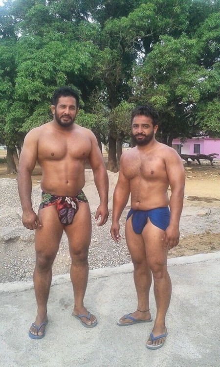 Wrestlers taking a break. The tall one looks like he’s got a big fat cock hiding in there somewhere.
