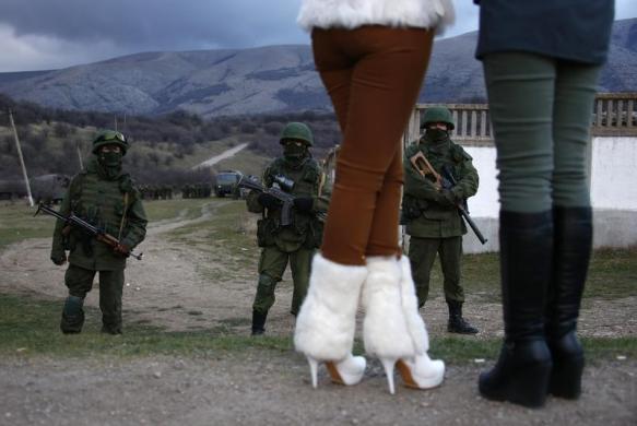 Perevalnoe, Ukraine
Local women watch armed men, believed to be Russian soldiers, assemble near a Ukrainian military base (via Reuters)