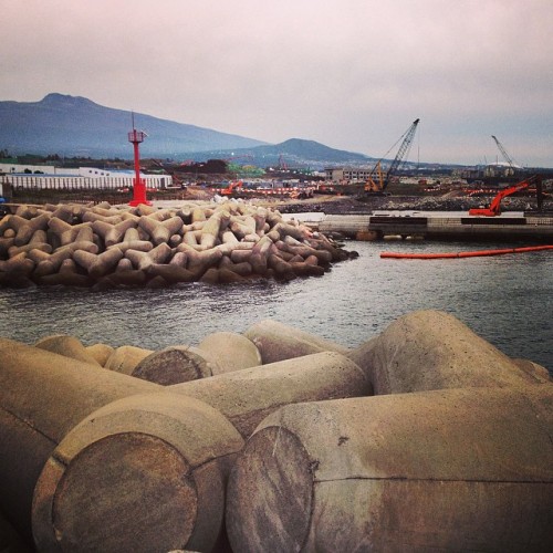 This is the view looking in towards the shore of Gangjeong from the sea. Beautiful jetties of metamorphic volcanic rock replaced by concrete. This used to be the site of Gureombi Rock, a sacred site of the village. It used to be a coral reef...