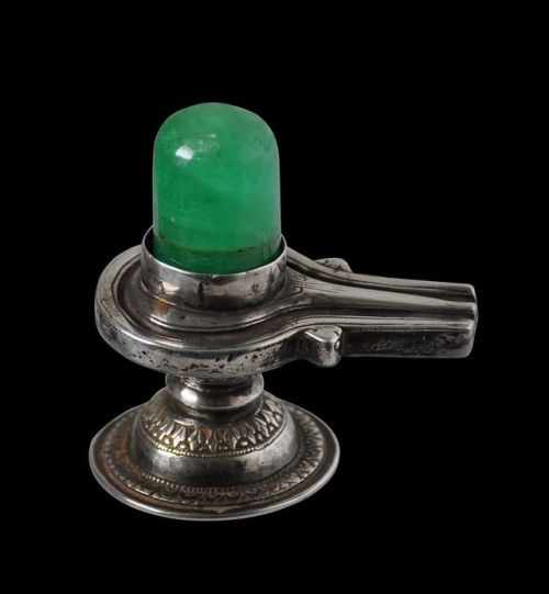 hinducosmos: Emerald Shiva Lingam 19th century India. Silver Shiva lingam set height of emerald: 3.4cm, weight of emerald: 188.88carats Overall height: 7.5cm, length: 7.3cm, width: 4.8cm, combined weight: 125g (via Michael Backman Ltd)