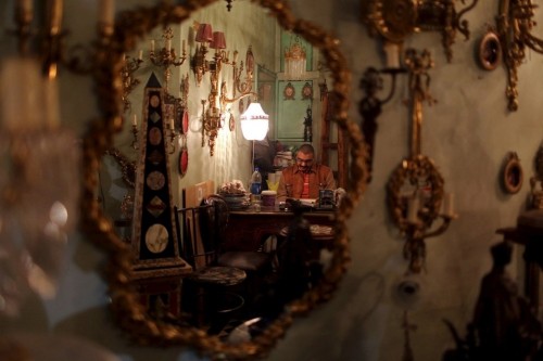 brassmanticore:The owner of an antique shop is seen reflected in a mirror at his store on Fouad Stre