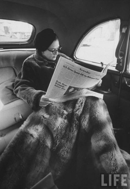 Newsday publisher Alicia Patterson reading her newspaper in backseat of her chauffeur-driven limousi