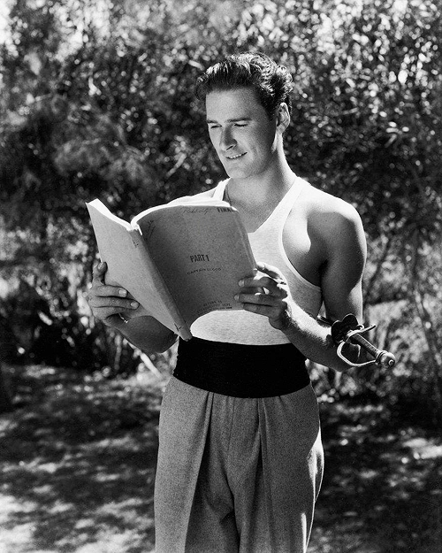 nostalgia-eh52:1935; Errol Flynn reading his script on the set of “Captain Blood" 