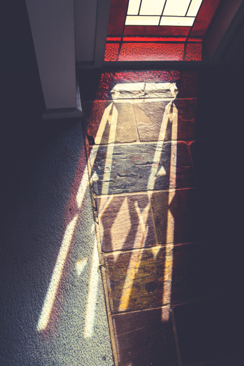 A coloured glass window, a dirty floor and some rare sunshine.