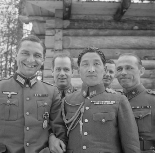 A Nazi officer poses with an officer from the Imperial Japanese Army, with Finnish soldiers behind, 