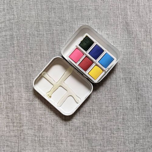 A tiny travel size watercolor kit made out of a tea box lid. I coated the inside with white enamel s