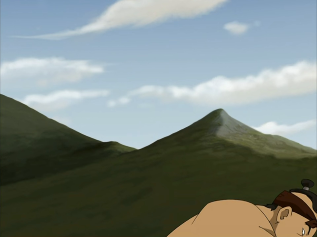 a mountain in the background. a shirtless man barely in the image on the bottom right.