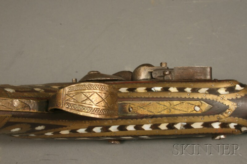 A pearly and brass decorated flintlock jezail originating from Afghanistan, lock is dated 1810.