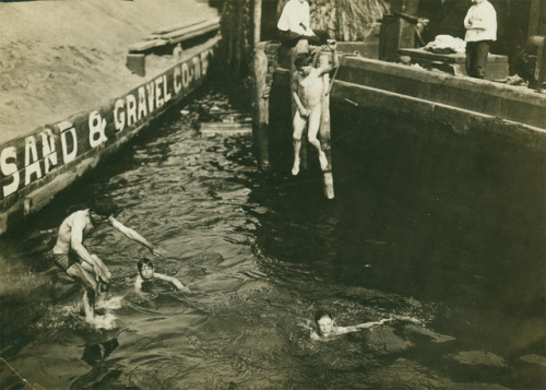 Children jump into the East River to go swimming on a hot summer day, 1907, New York City.