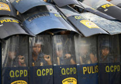 politics-war:  Filipino riot policemen use their shield as they wait for protestors dismantle their barricade as they attempt to reach the Philippine Congress in Quezon City, east of Manila, Philippines.