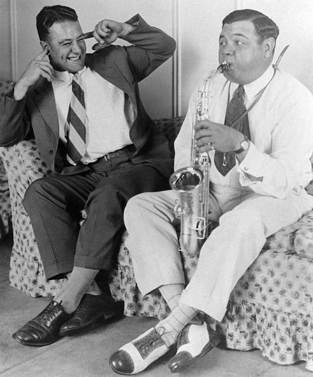 siphotos:  Lou Gehrig plugs his ears as Babe Ruth blows into a saxophone in 1928.