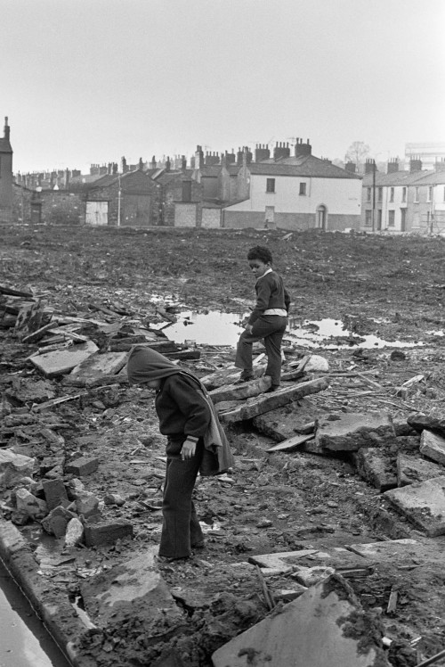 Children playing where old terraced houses have been demolished to make way for redevelopment, Pill,