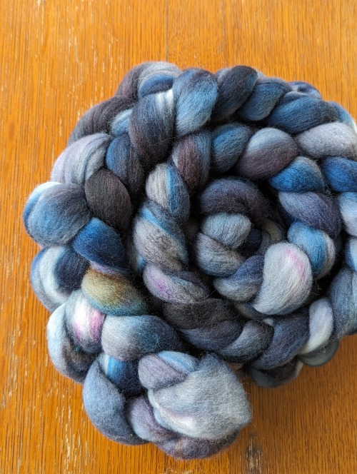 a braid of fibre in blue and grey, with hints of pink and yellow