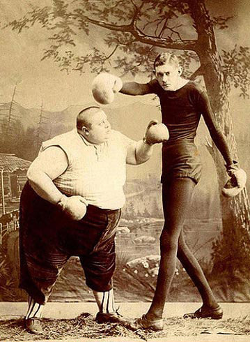 Two Victorian sideshow performers boxing | The fat man and the thin man