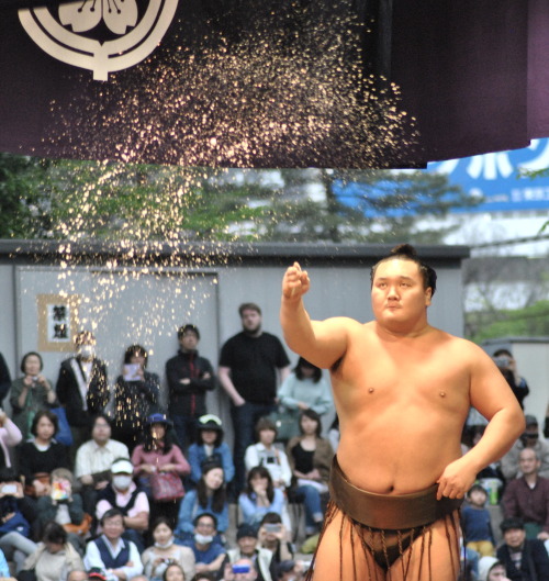 Sumo Champion Hakuho throwing salt to purify the ring before his match at an outdoor sumo event in T