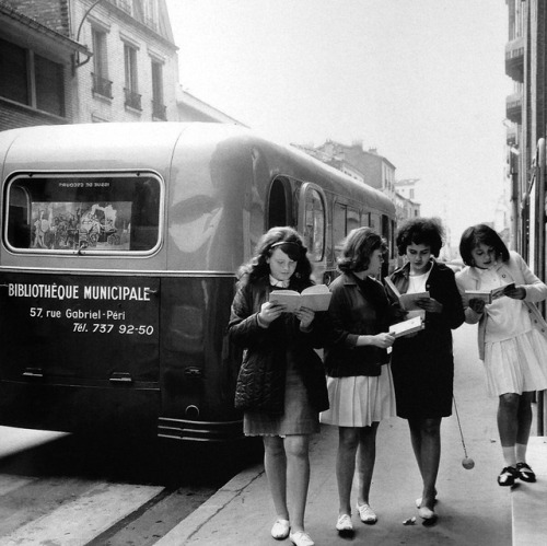 vintageeveryday:Girls reading books from mobile library in Levallois-Perret, near Paris, circa 1960.