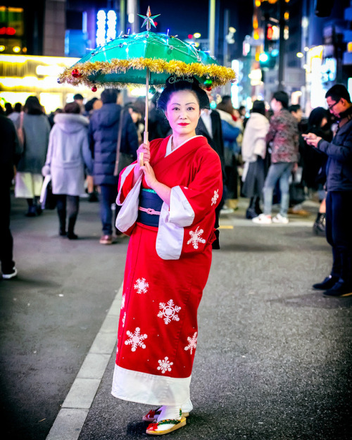 Japanese woman in Christmas kimono and decorated lit up umbrella (wagasa) on the street in Harajuku 