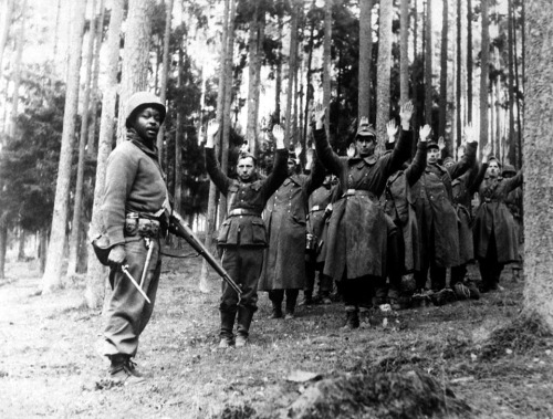 A Soldier of the 12th Armored Division Stands Guard Over German POWs in April 1945. Courtesy of NARA