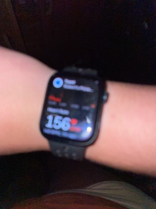 an image of a black Apple Watch on a light tan wrist reading heart rate at 156 beats per minute