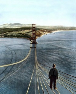 urbain:  A man stands on cables over the Golden Gate Bridge, circa 1933