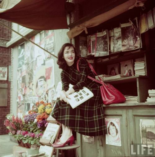 Actress Peggy O'Connor reading at newsstand on sound stage. Los Angeles, 1950. Photographer: Loomis 