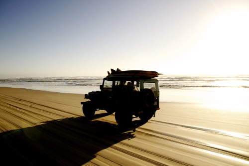 A surfboard-laden jeep skimming the shore at Santa Barbara beachDo you share our passion for the oce