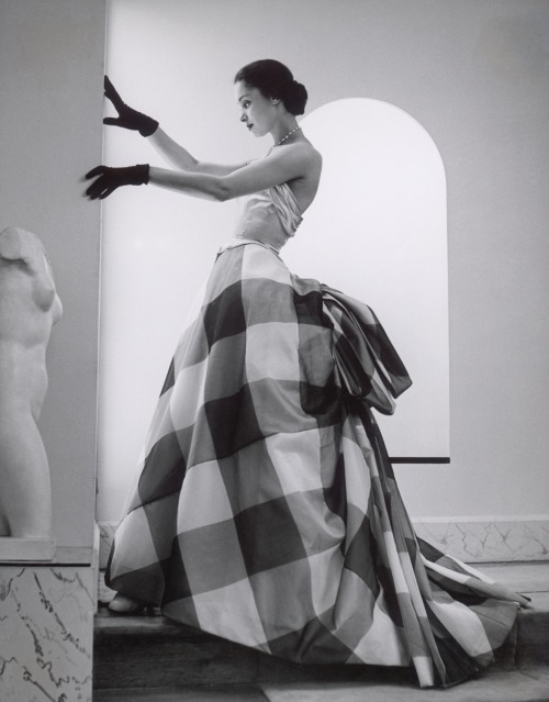 Model with sculpture (1952). Photograph by André Ostier-Heil.Model is wearing a silk dress by